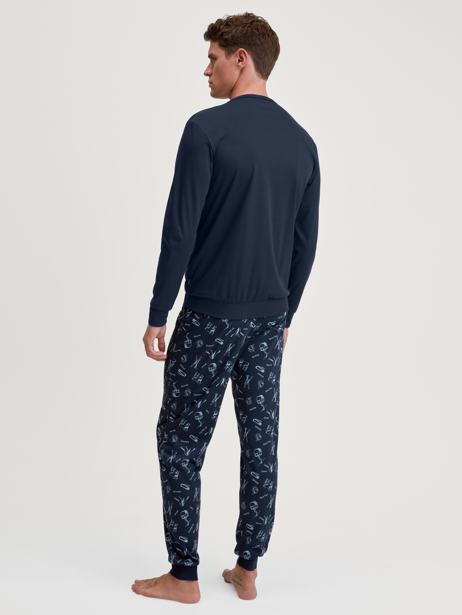 Herren-Model trägt Bündchen-Pyjama aus 100% Baumwolle in Blau, Gemustert aus Serie Relax Swiss Resort von CALIDA, Rückansicht