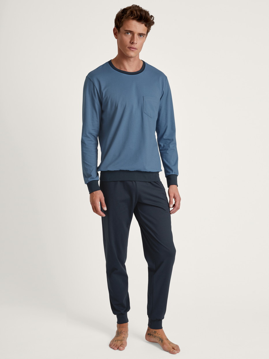 Herren-Model trägt Bündchen-Pyjama aus 100% Baumwolle in Blau, Einfarbig aus Serie Relax Essentials von CALIDA, Vorderansicht