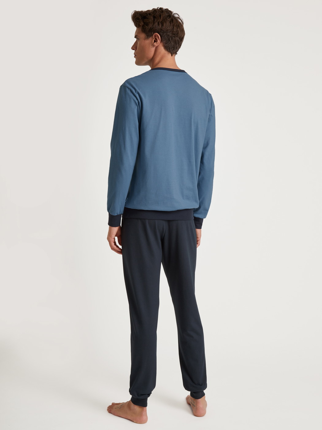 La modella / Il modello Uomo indossa Pigiama con polsini in 100% cotone di colore Blu, Tinta unita, della serie Relax Essentials di CALIDA, Vista posteriore