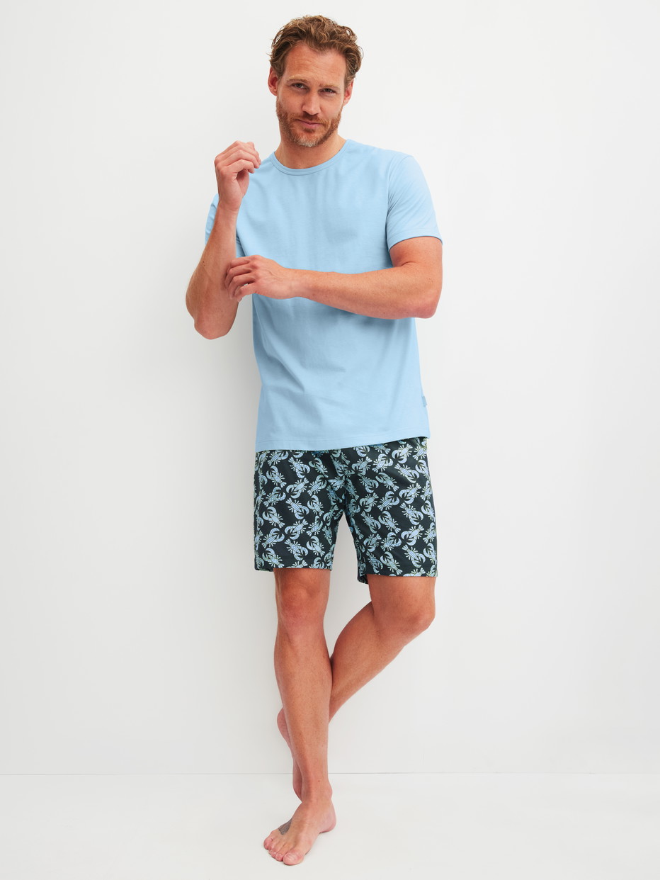 Herren-Model trägt Kurz-Pyjama aus 100% Baumwolle in Blau, Gemustert aus Serie Relax Imprint 2 von CALIDA, Vorderansicht