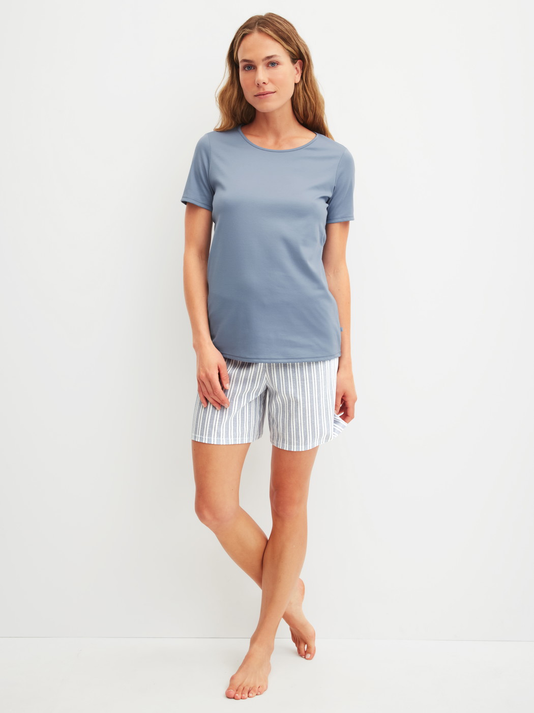 Damen-Model trägt Kurz-Pyjama aus 100% Baumwolle in Blau, Gestreift aus Serie Striped Dreams von CALIDA, Vorderansicht