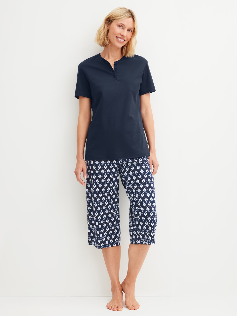 Women model is wearing Capri Pyjama made of 100% Cotton in Blue, Patterned from the Daylight Dreams series by CALIDA, Front view