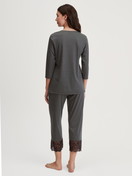Damen-Model trägt 7/8-Pyjama aus Baumwolle in Schwarz, Spitze aus Serie Deep Dreams von CALIDA, Rückansicht
