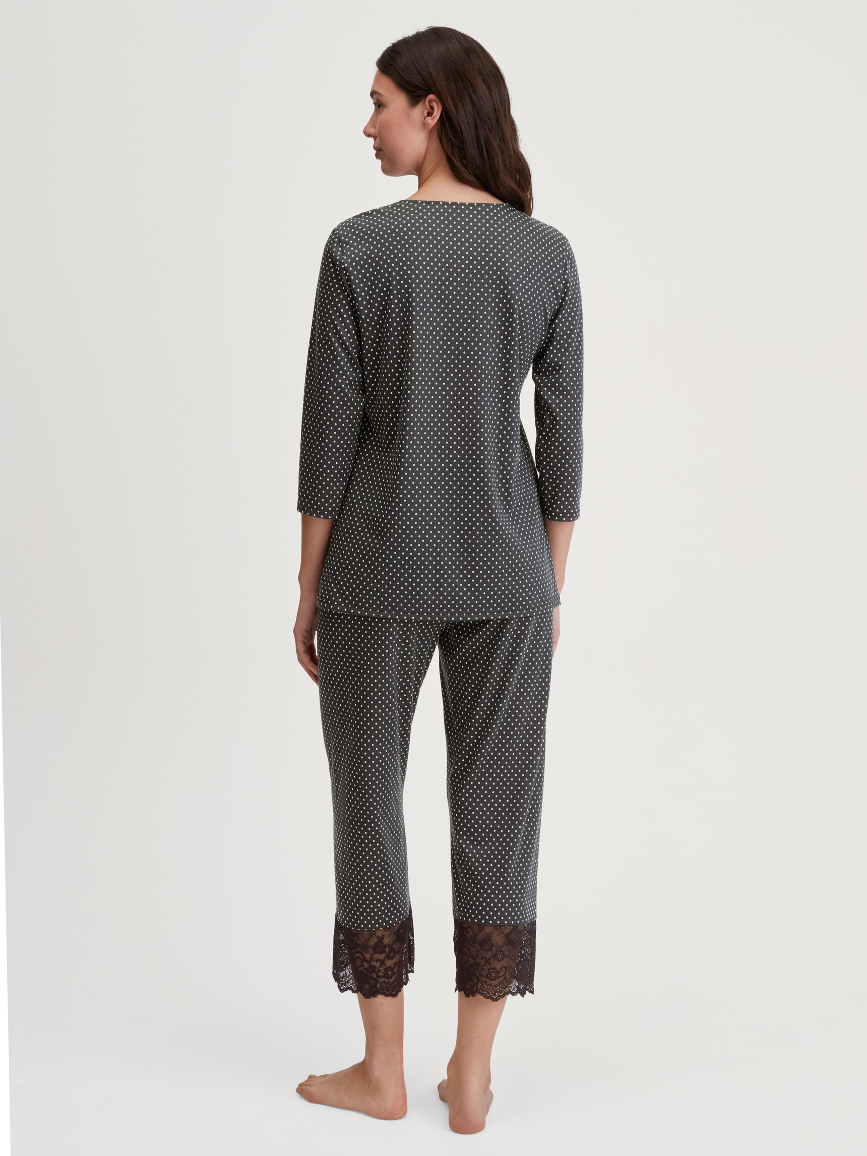 Damen-Model trägt 7/8-Pyjama aus Baumwolle in Schwarz, Spitze aus Serie Deep Dreams von CALIDA, Rückansicht