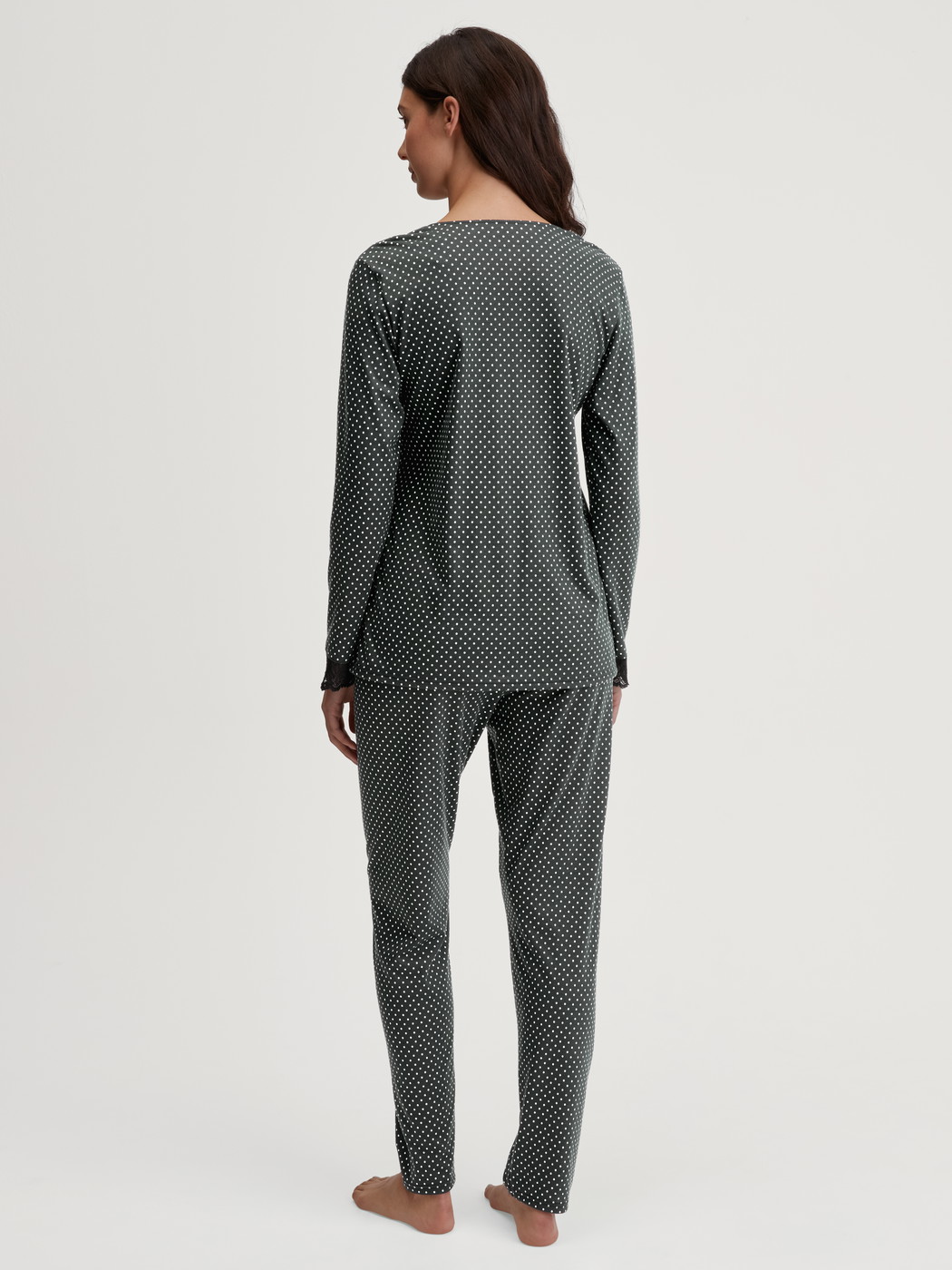 Damen-Model trägt Pyjama, lang aus Baumwolle in Schwarz, Spitze aus Serie Deep Dreams von CALIDA, Rückansicht