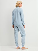 Women model is wearing Ribbed Cuff Pyjamas made of 100% Cotton in Blue, Patterned from the Midnight Dreams series by CALIDA, Back view