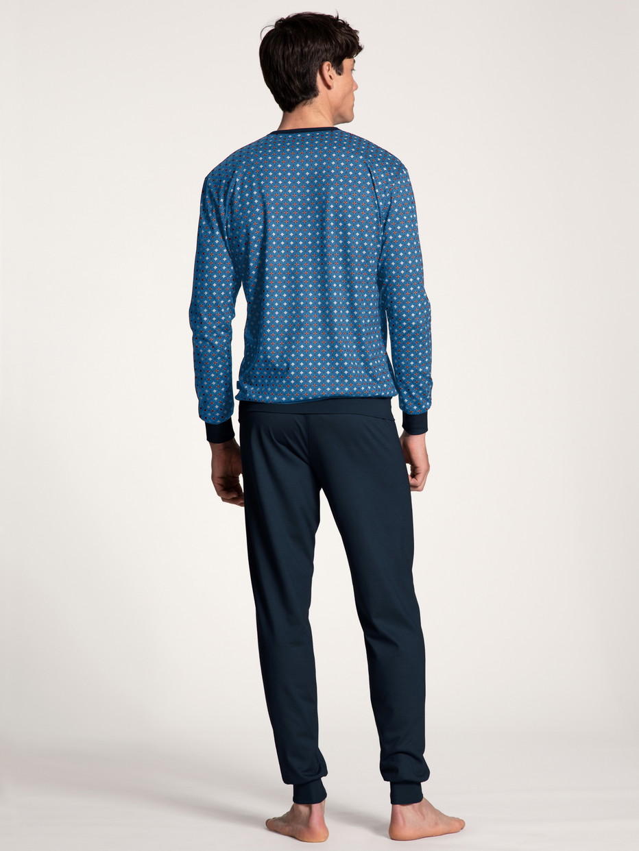 Herren-Model trägt Bündchen-Pyjama aus 100% Baumwolle in Blau, Gemustert aus Serie Nightwear Xtra von CALIDA, Rückansicht