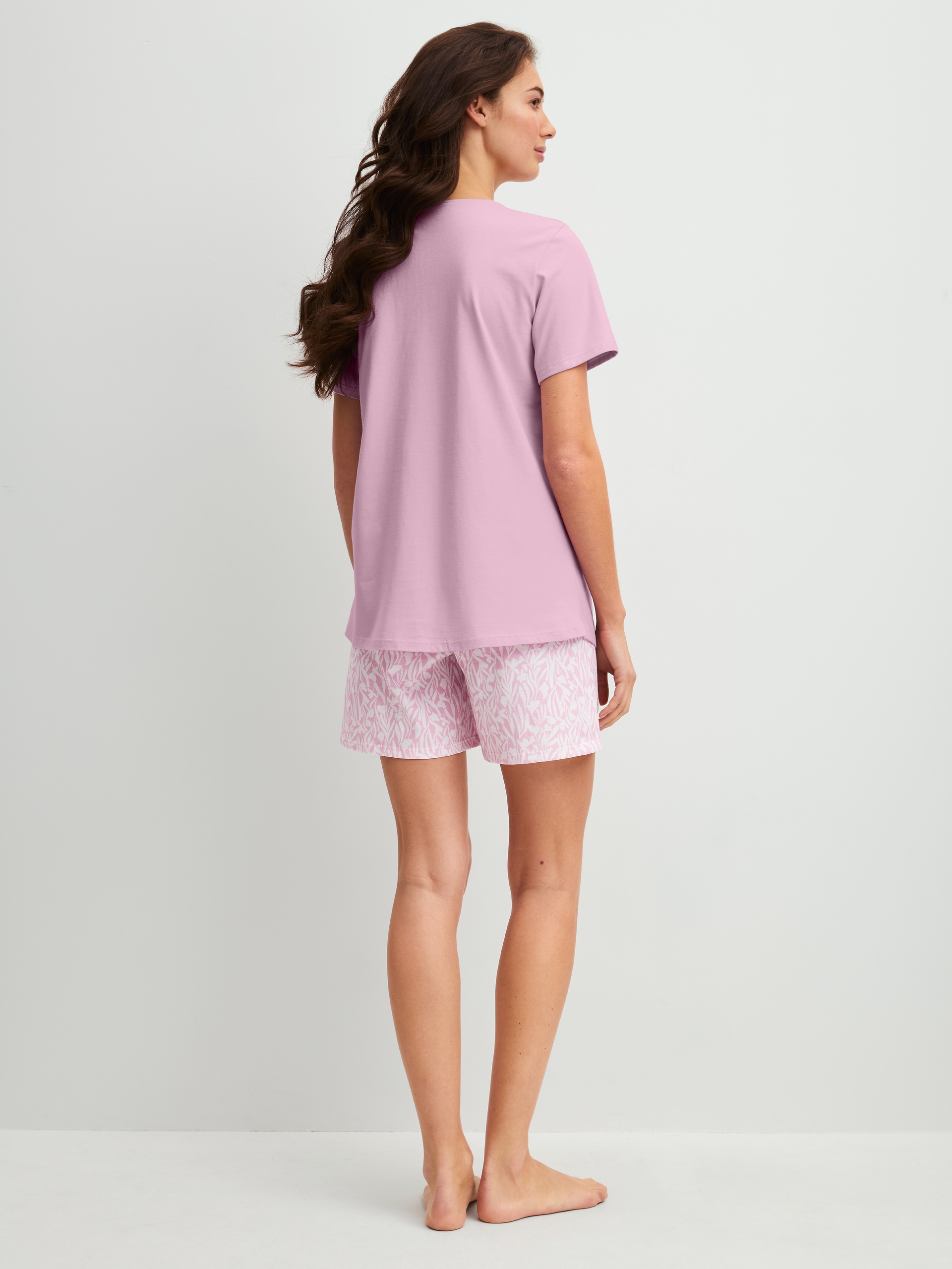 Women model is wearing Short pyjamas made of 100% Cotton in Purple, Patterned from the Blooming Nights series by CALIDA, Back view