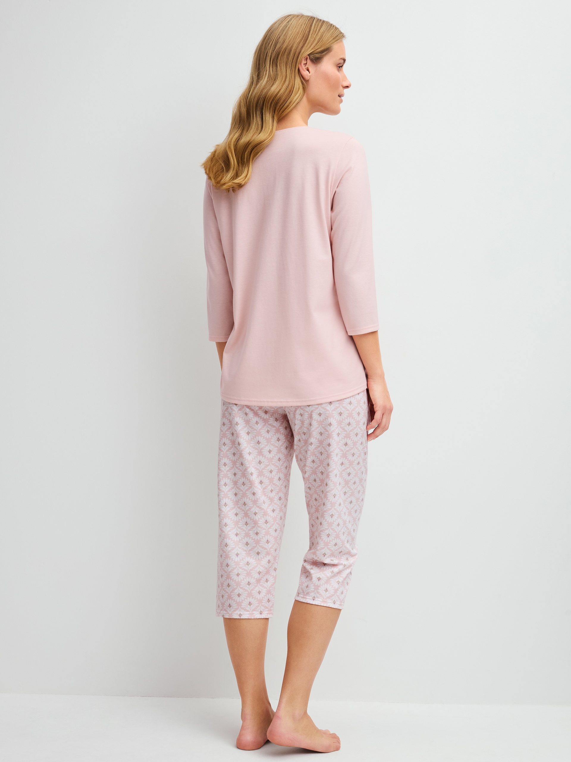 Women model is wearing Capri Pyjama made of 100% Cotton in Pink, Floral from the Cotton Special series by CALIDA, Back view