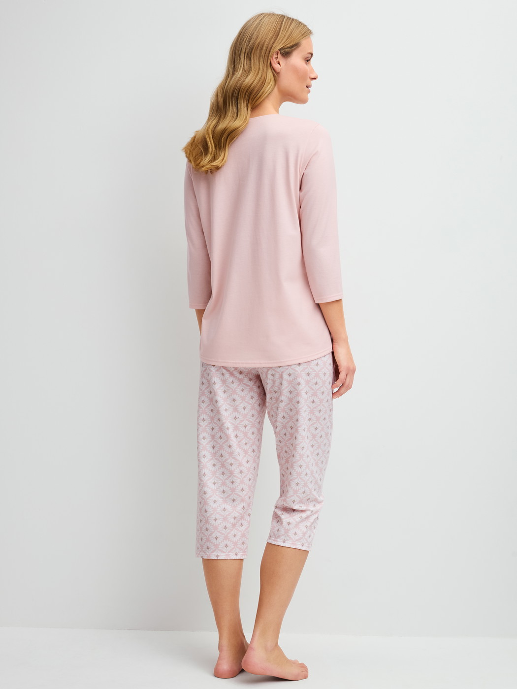Women model is wearing Capri Pyjama made of 100% Cotton in Pink, Floral from the Cotton Special series by CALIDA, Back view