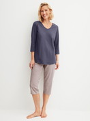 Women model is wearing Capri Pyjama made of 100% Cotton in Blue, Patterned from the Graphic Nights series by CALIDA, Front view