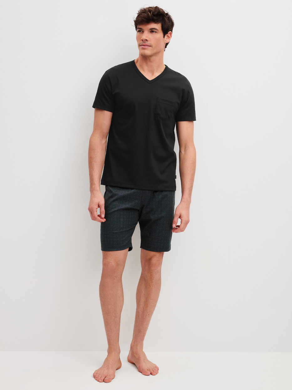 Herren-Model trägt Kurz-Pyjama aus 100% Baumwolle in Schwarz, Gemustert aus Serie Relax Streamline 2 von CALIDA, Vorderansicht