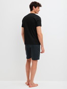 Herren-Model trägt Kurz-Pyjama aus 100% Baumwolle in Schwarz, Gemustert aus Serie Relax Streamline 2 von CALIDA, Rückansicht