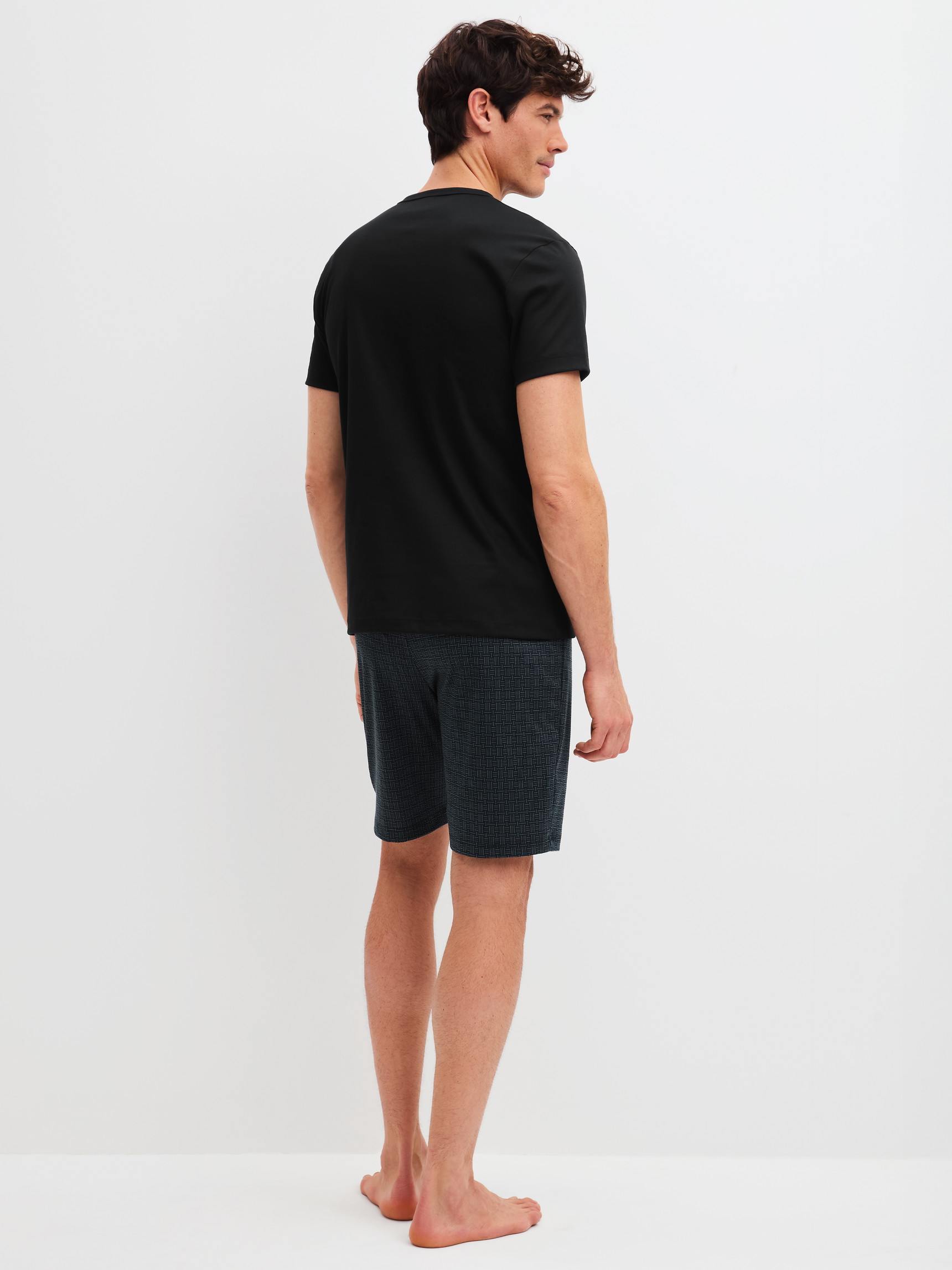 Herren-Model trägt Kurz-Pyjama aus 100% Baumwolle in Schwarz, Gemustert aus Serie Relax Streamline 2 von CALIDA, Rückansicht