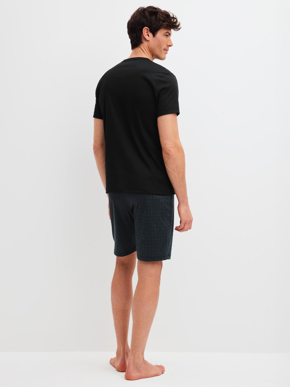 Herren-Model trägt Kurz-Pyjama aus 100% Baumwolle in Schwarz, Gemustert aus Serie Relax Streamline 2 von CALIDA, Rückansicht
