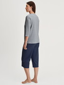 Women model is wearing Capri Pyjama made of 100% Cotton in Blue, Patterned from the Cotton Special series by CALIDA, Back view