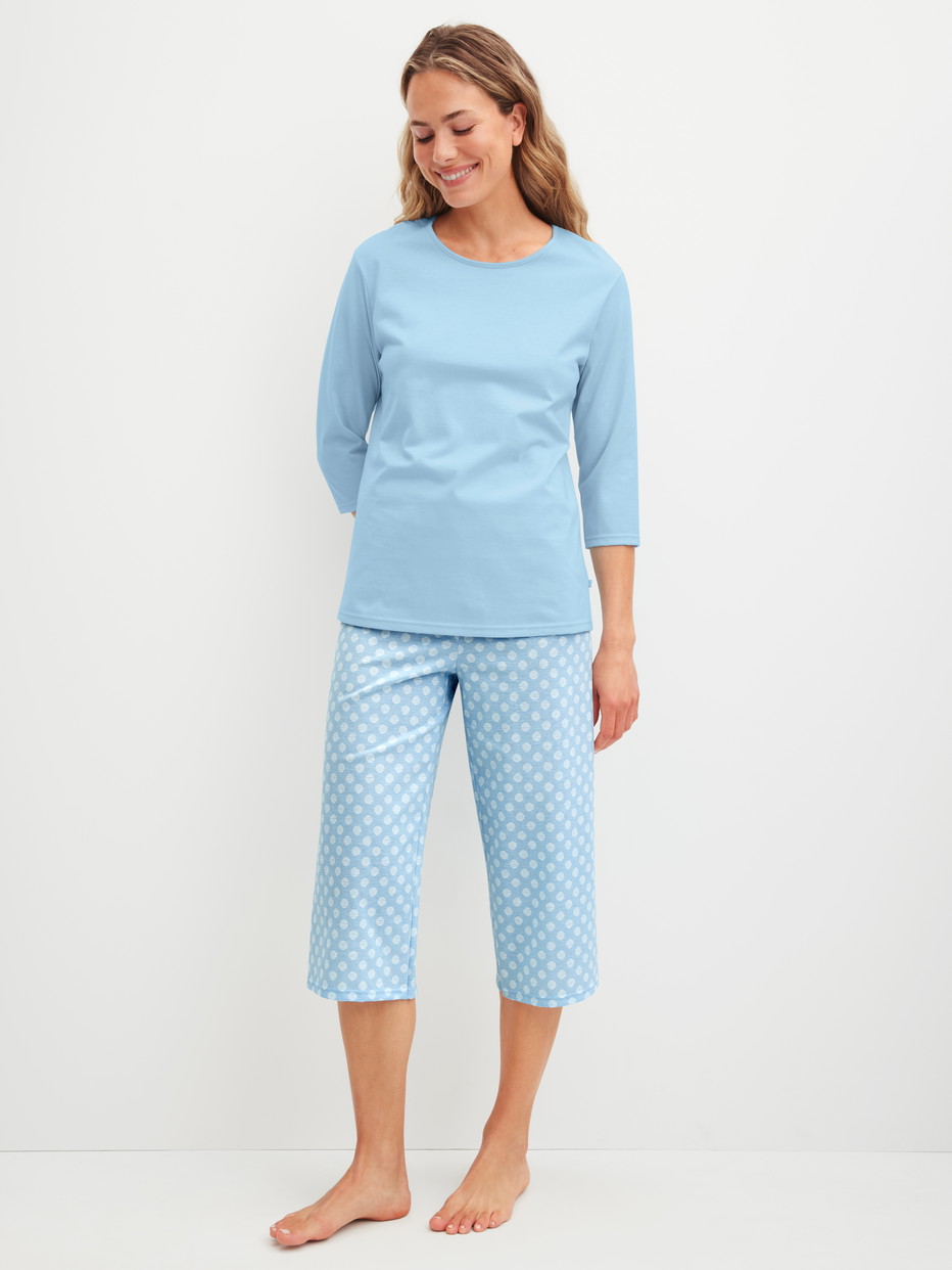 Damen-Model trägt Capri-Pyjama aus 100% Baumwolle in Blau, Gemustert aus Serie Lovely Nights von CALIDA, Vorderansicht