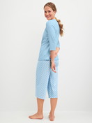 Women model is wearing Capri Pyjama made of 100% Cotton in Blue, Patterned from the Lovely Nights series by CALIDA, Back view