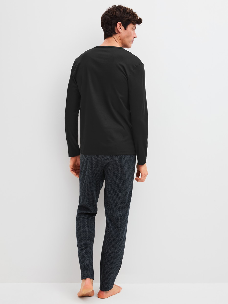 Herren-Model trägt Pyjama, lang aus 100% Baumwolle in Schwarz, Gemustert aus Serie Relax Streamline 2 von CALIDA, Rückansicht