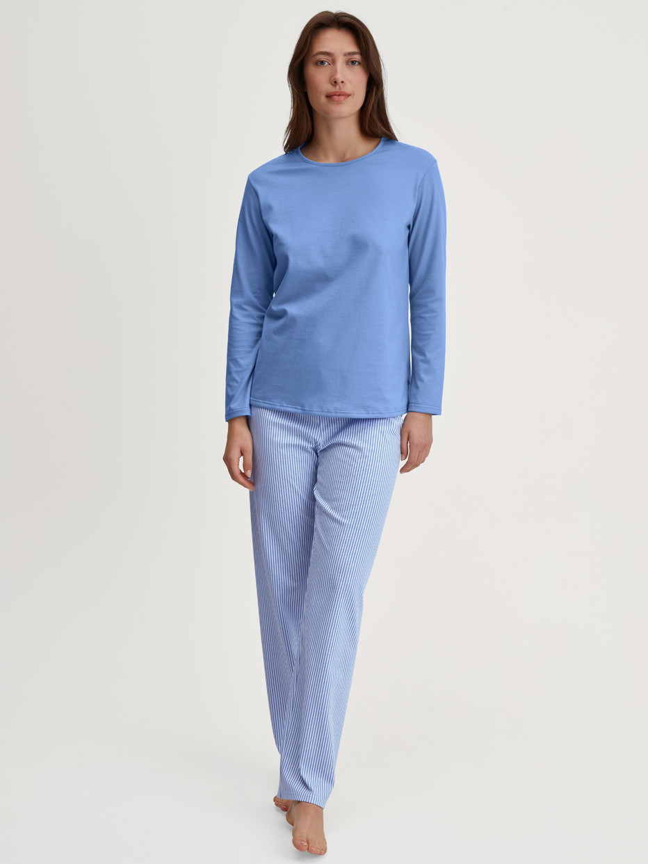 Women model is wearing Pyjamas, long made of 100% Cotton in Blue, Patterned from the Lovely Nights series by CALIDA, Front view