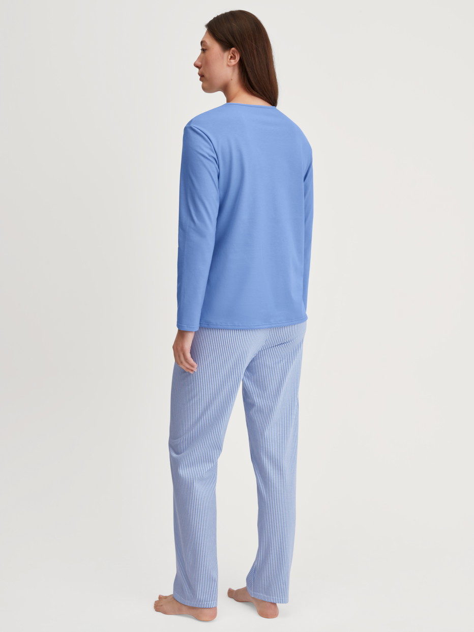 Women model is wearing Pyjamas, long made of 100% Cotton in Blue, Patterned from the Lovely Nights series by CALIDA, Back view