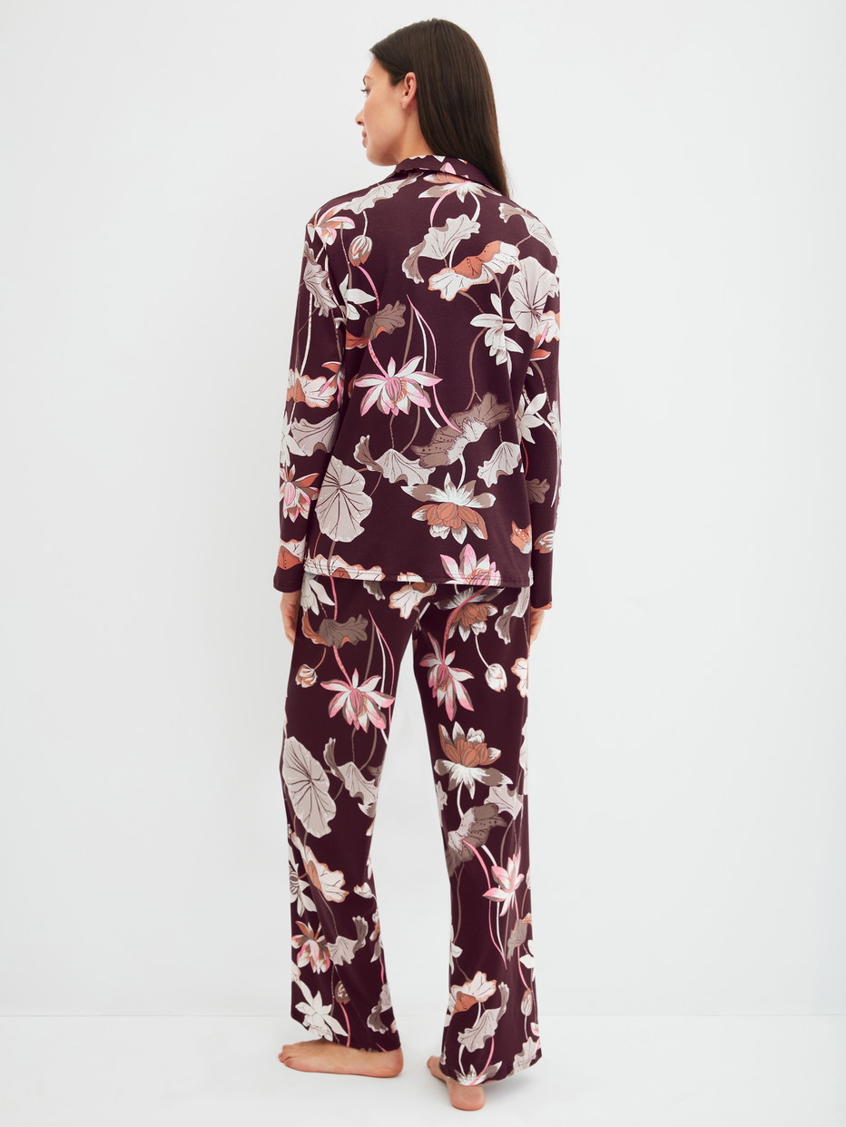 Damen-Model trägt Pyjama mit Knöpfen aus 100% Baumwolle in Rot, Floral aus Serie Season Special von CALIDA, Rückansicht