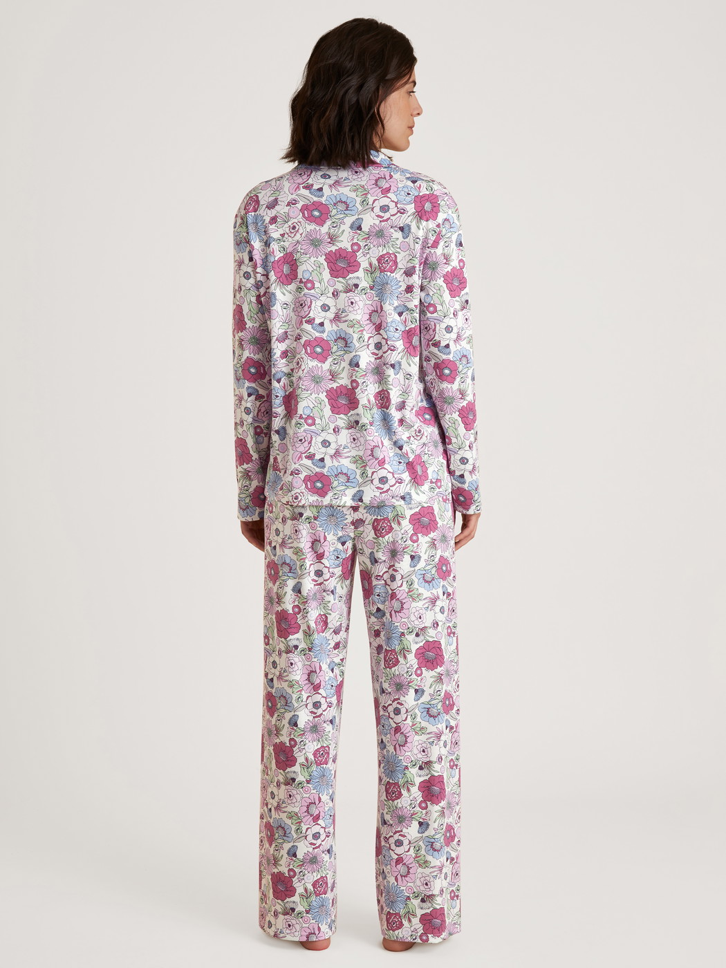 Women model is wearing Button-Up Pyjama made of 100% Cotton in Purple, Floral from the Spring Flower Dreams series by CALIDA, Back view