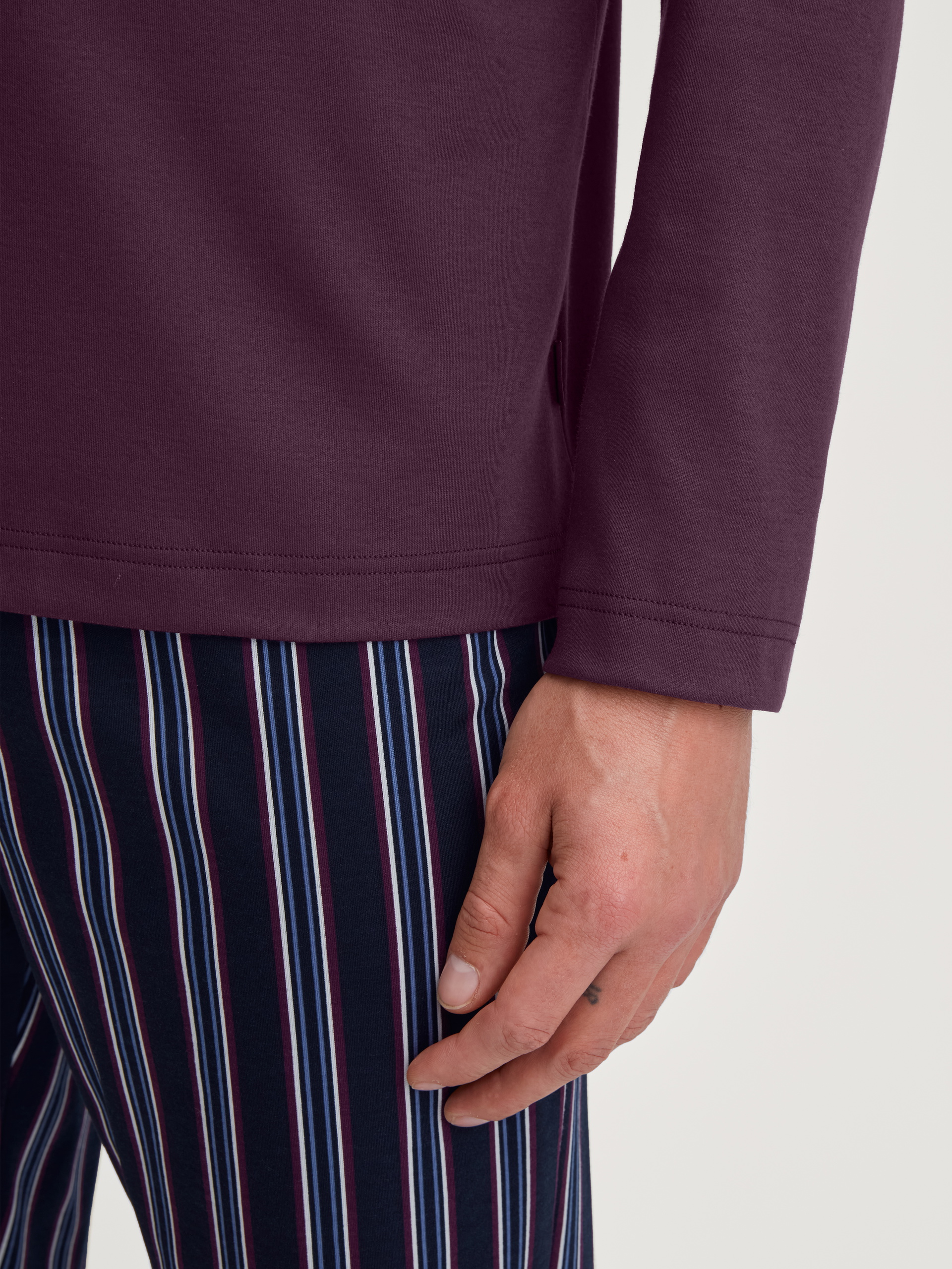 Herren-Model trägt Pyjama, lang aus 100% Baumwolle in Rot, Gestreift aus Serie Relax Streamline 4 von CALIDA, Detail