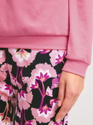 Damen-Model trägt Bündchen-Pyjama aus 100% Baumwolle in Rosa, Floral aus Serie Autumn Dreams von CALIDA, Detail