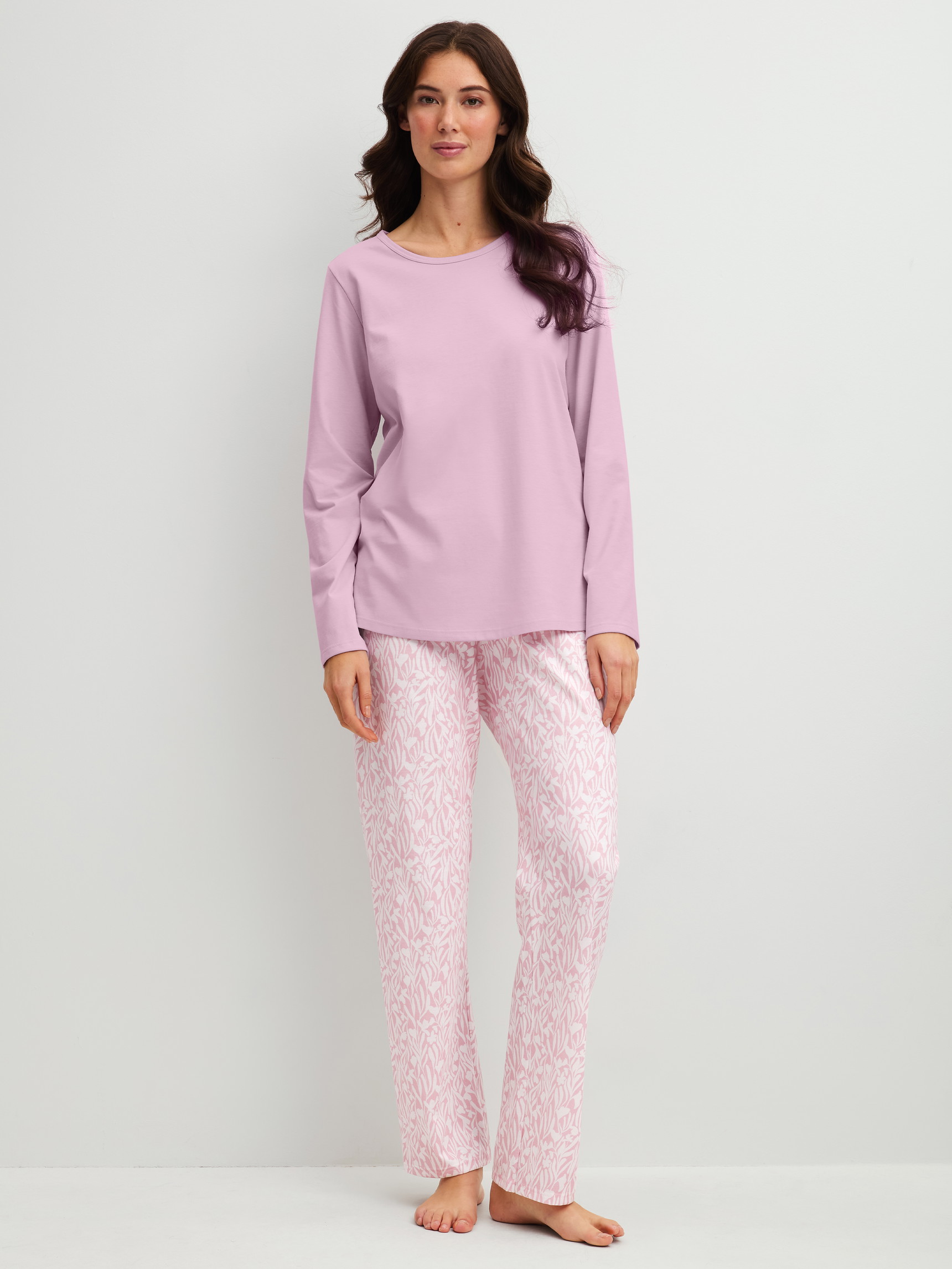 Women model is wearing Pyjamas, long made of 100% Cotton in Purple, Patterned from the Blooming Nights series by CALIDA, Front view