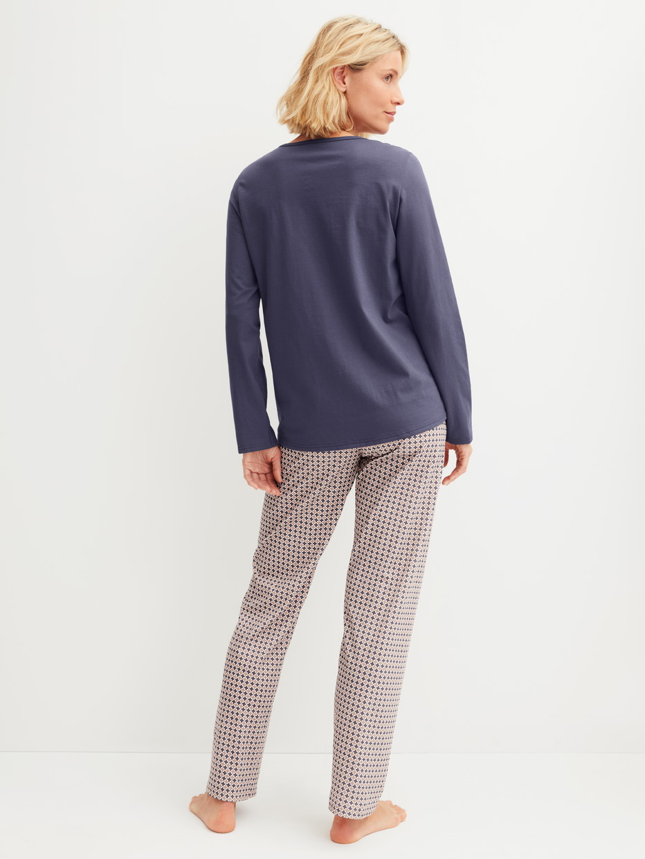 Women model is wearing Pyjamas, long made of 100% Cotton in Blue, Patterned from the Graphic Nights series by CALIDA, Back view