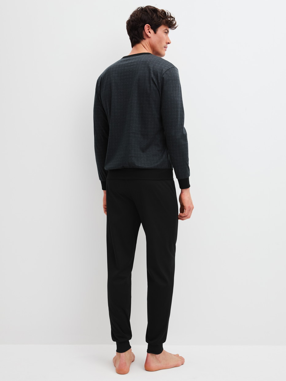 Herren-Model trägt Bündchen-Pyjama aus 100% Baumwolle in Schwarz, Gemustert aus Serie Relax Streamline 2 von CALIDA, Rückansicht