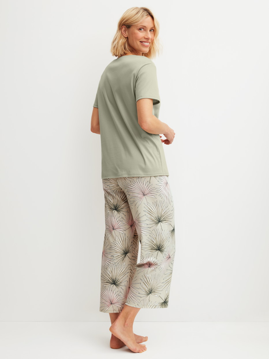 Damen-Model trägt 7/8-Pyjama aus 100% Baumwolle in Grün, Floral aus Serie Leaf Dreams von CALIDA, Rückansicht