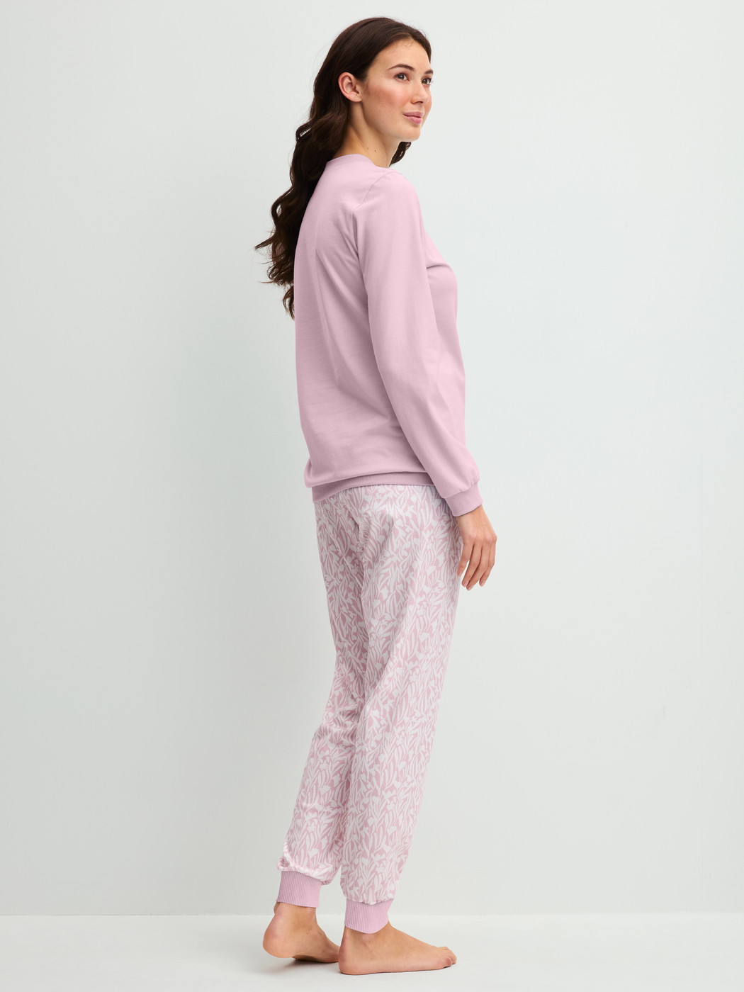 Women model is wearing Pyjama with cuff made of 100% Cotton in Purple, Patterned from the Blooming Nights series by CALIDA, Back view