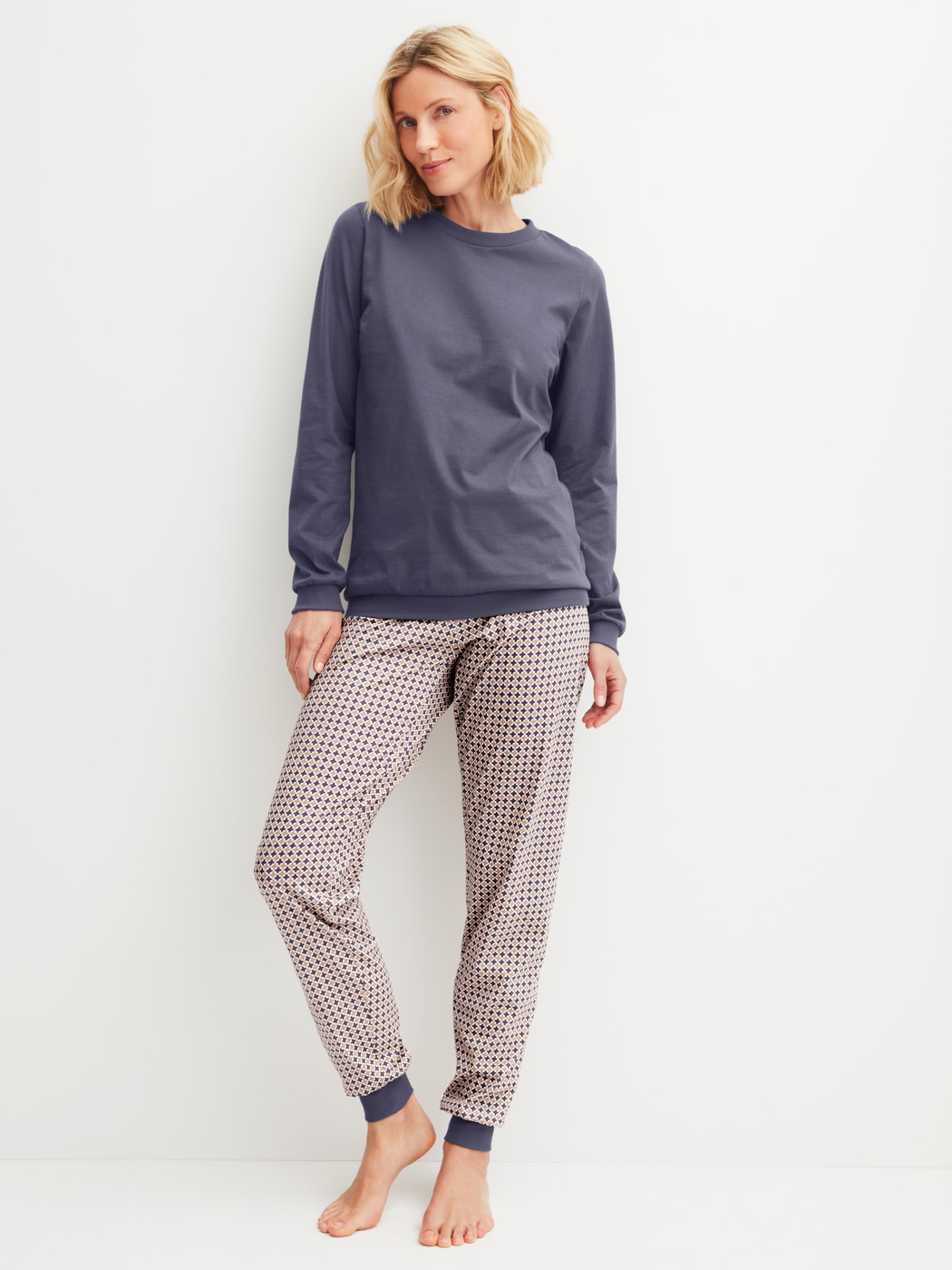 Damen-Model trägt Bündchen-Pyjama aus 100% Baumwolle in Blau, Gemustert aus Serie Graphic Nights von CALIDA, Vorderansicht