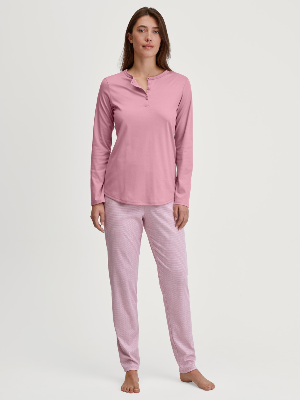 La modella / Il modello Donna indossa Pigiami, lunghi in 100% cotone di colore Rosa, A righe, della serie Striped Dreams di CALIDA, Vista frontale