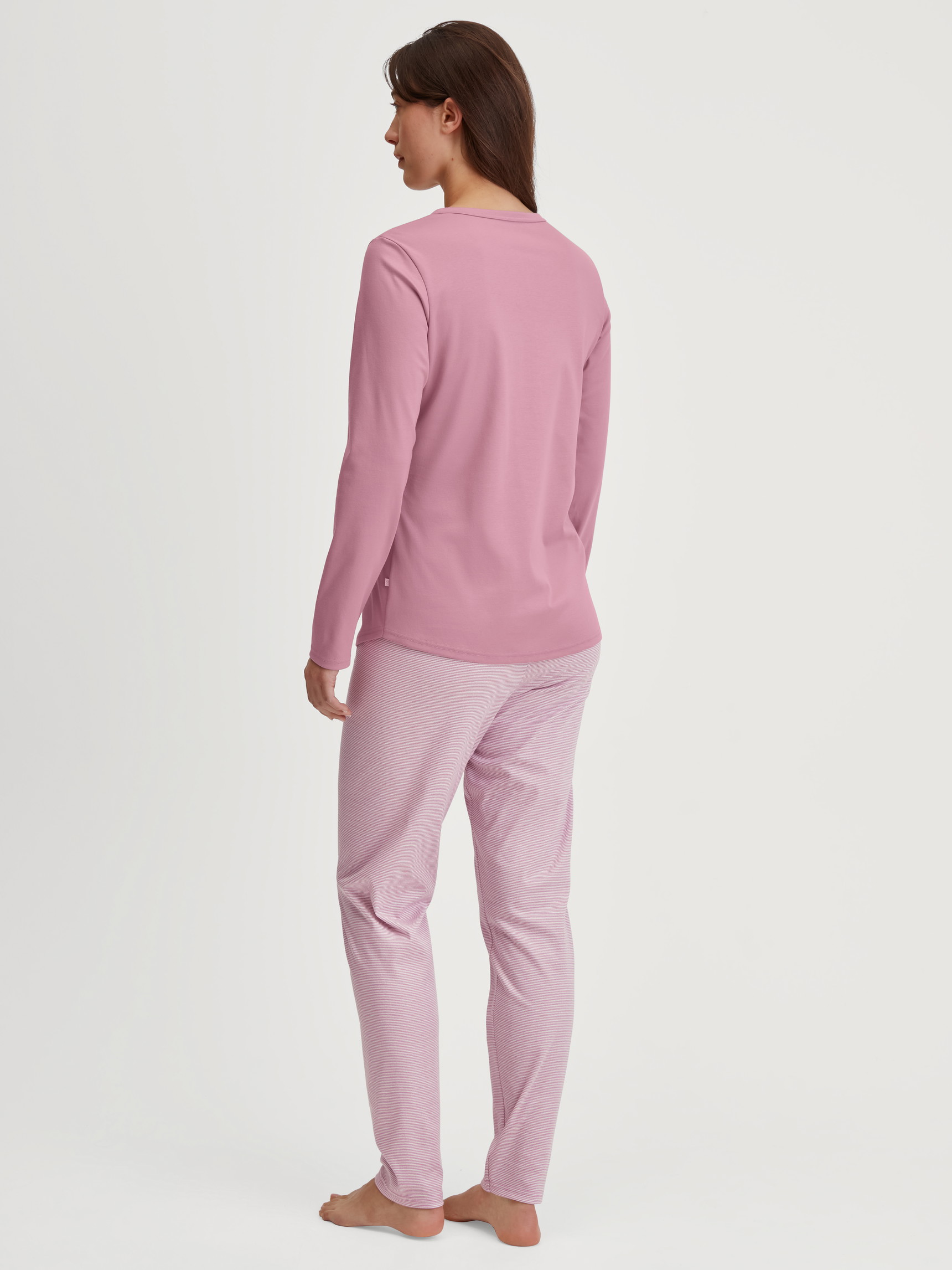 Women model is wearing Pyjamas, long made of 100% Cotton in Pink, Striped from the Striped Dreams series by CALIDA, Back view