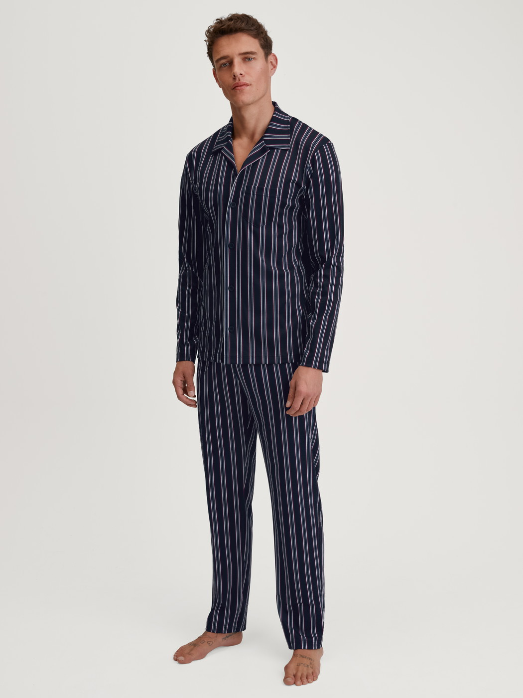 La modella / Il modello Uomo indossa Pigiama con bottoni in 100% cotone di colore Blu, A righe, della serie Relax Streamline 4 di CALIDA, Vista frontale