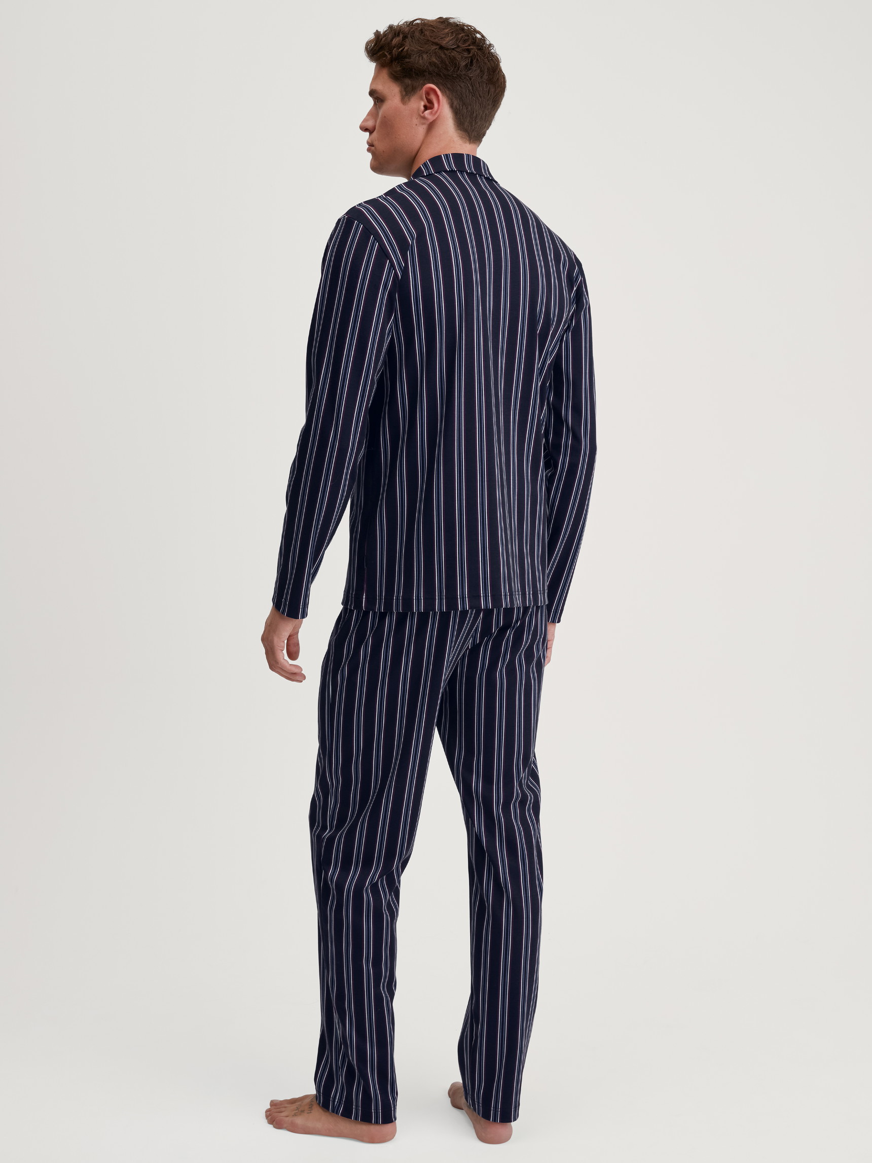 Herren-Model trägt Pyjama mit Knöpfen aus 100% Baumwolle in Blau, Gestreift aus Serie Relax Streamline 4 von CALIDA, Rückansicht