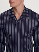 La modella / Il modello Uomo indossa Pigiama con bottoni in 100% cotone di colore Blu, A righe, della serie Relax Streamline 4 di CALIDA, Dettaglio