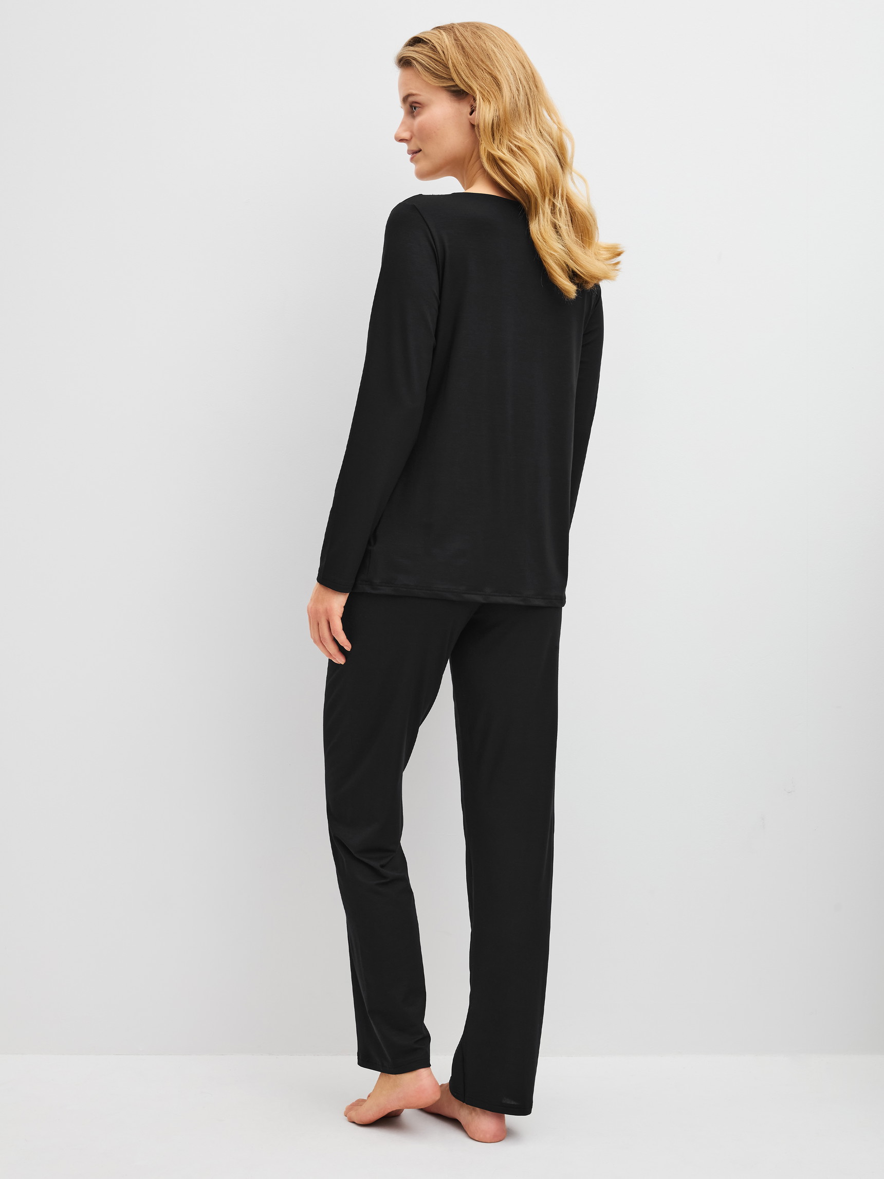 Damen-Model trägt Pyjama, lang aus Modal in Schwarz, Spitze aus Serie Elegant Dreams von CALIDA, Rückansicht