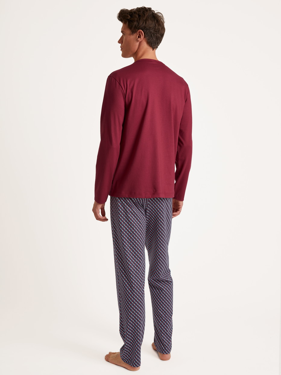 Herren-Model trägt Pyjama, lang aus 100% Baumwolle in Rot, Gemustert aus Serie Relax Imprint von CALIDA, Rückansicht
