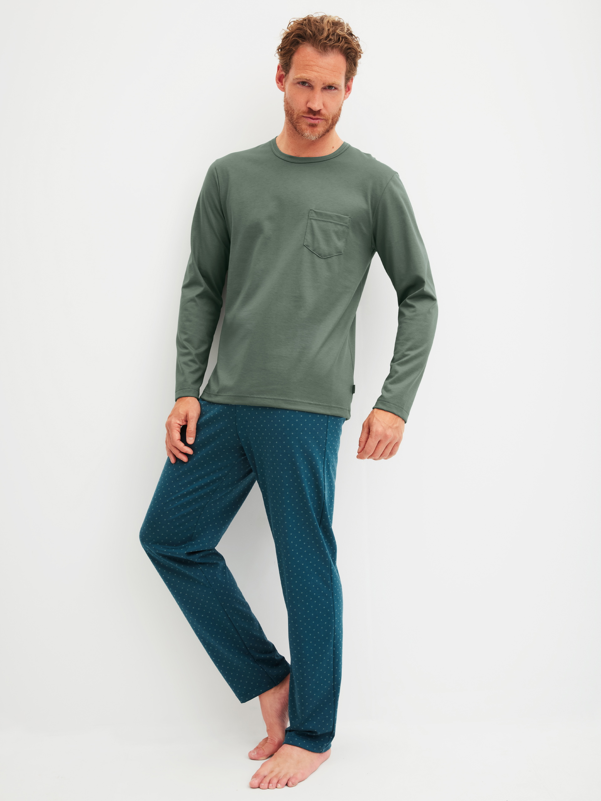 Herren-Model trägt Pyjama, lang aus 100% Baumwolle in Grün, Gemustert aus Serie Relax Imprint 1 von CALIDA, Vorderansicht