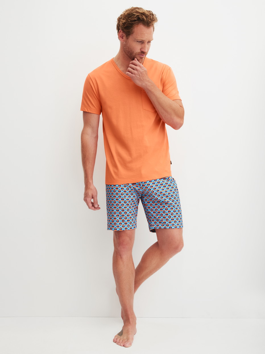 Herren-Model trägt Kurz-Pyjama aus 100% Baumwolle in Orange, Gemustert aus Serie Relax Imprint 4 von CALIDA, Vorderansicht