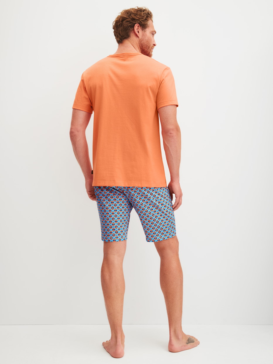 Herren-Model trägt Kurz-Pyjama aus 100% Baumwolle in Orange, Gemustert aus Serie Relax Imprint 4 von CALIDA, Rückansicht