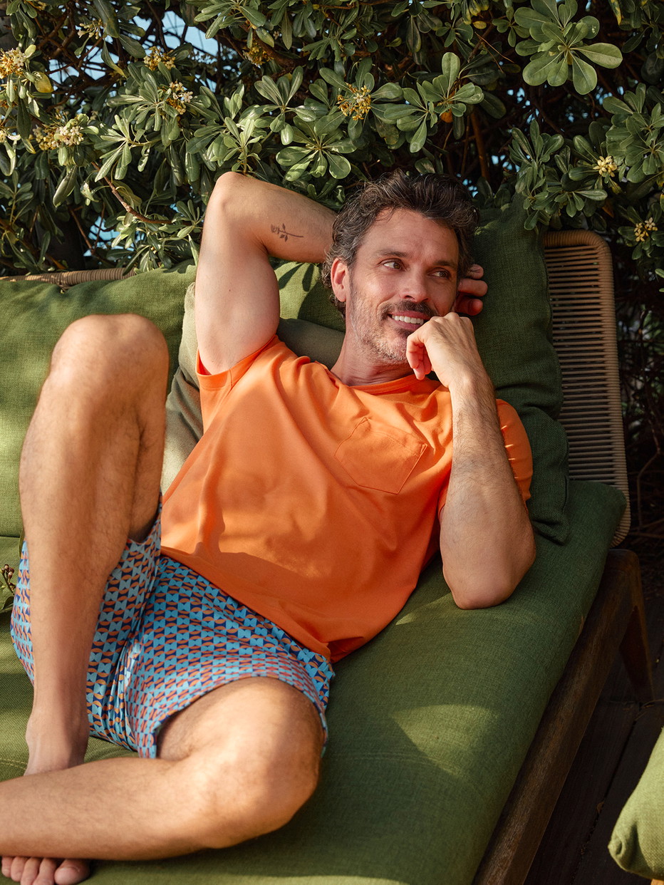 Herren-Model trägt Kurz-Pyjama aus 100% Baumwolle in Orange, Gemustert aus Serie Relax Imprint 4 von CALIDA, Vorderansicht