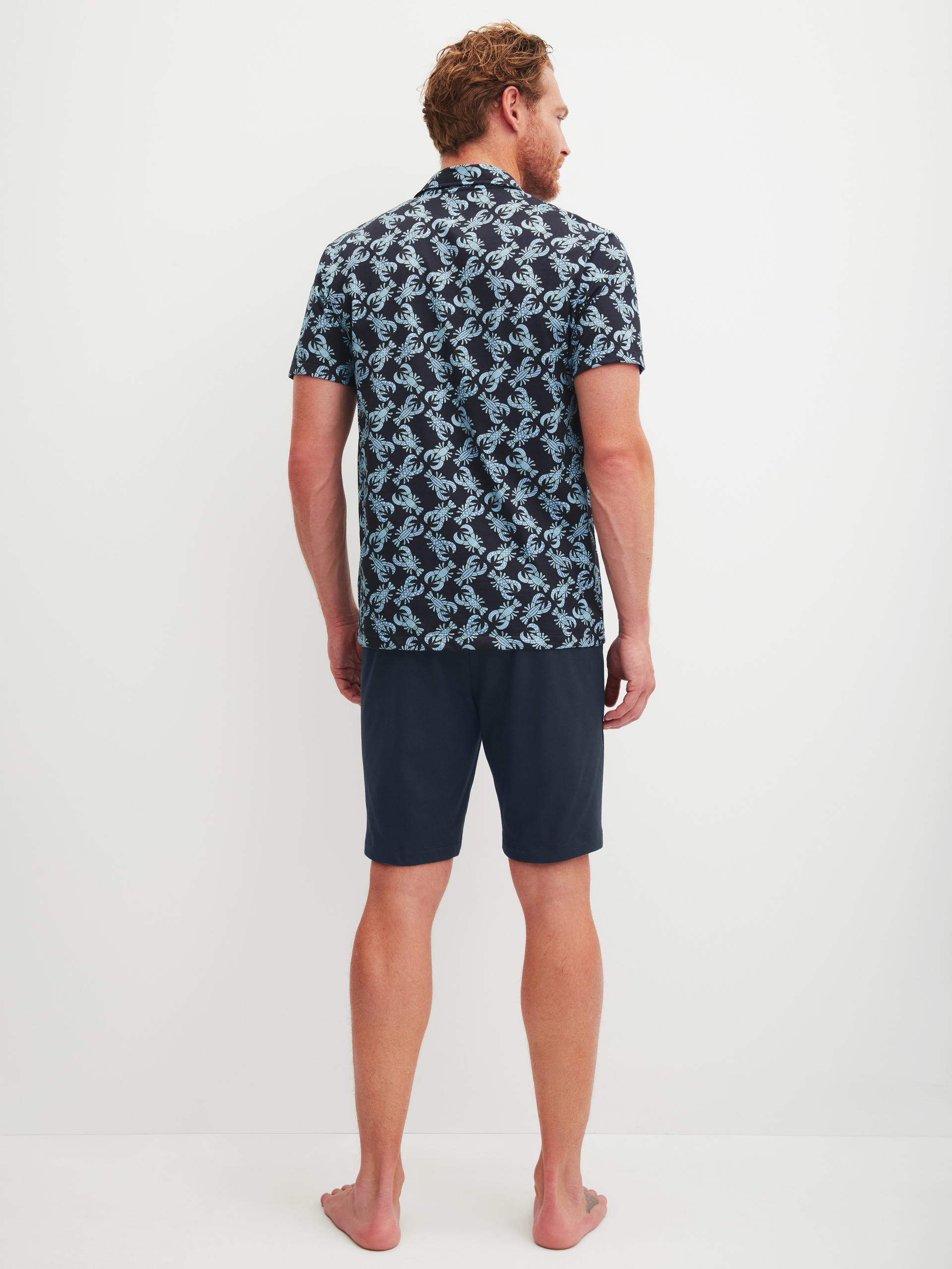 Herren-Model trägt Kurz-Pyjama aus 100% Baumwolle in Blau, Gemustert aus Serie Relax Imprint 2 von CALIDA, Rückansicht