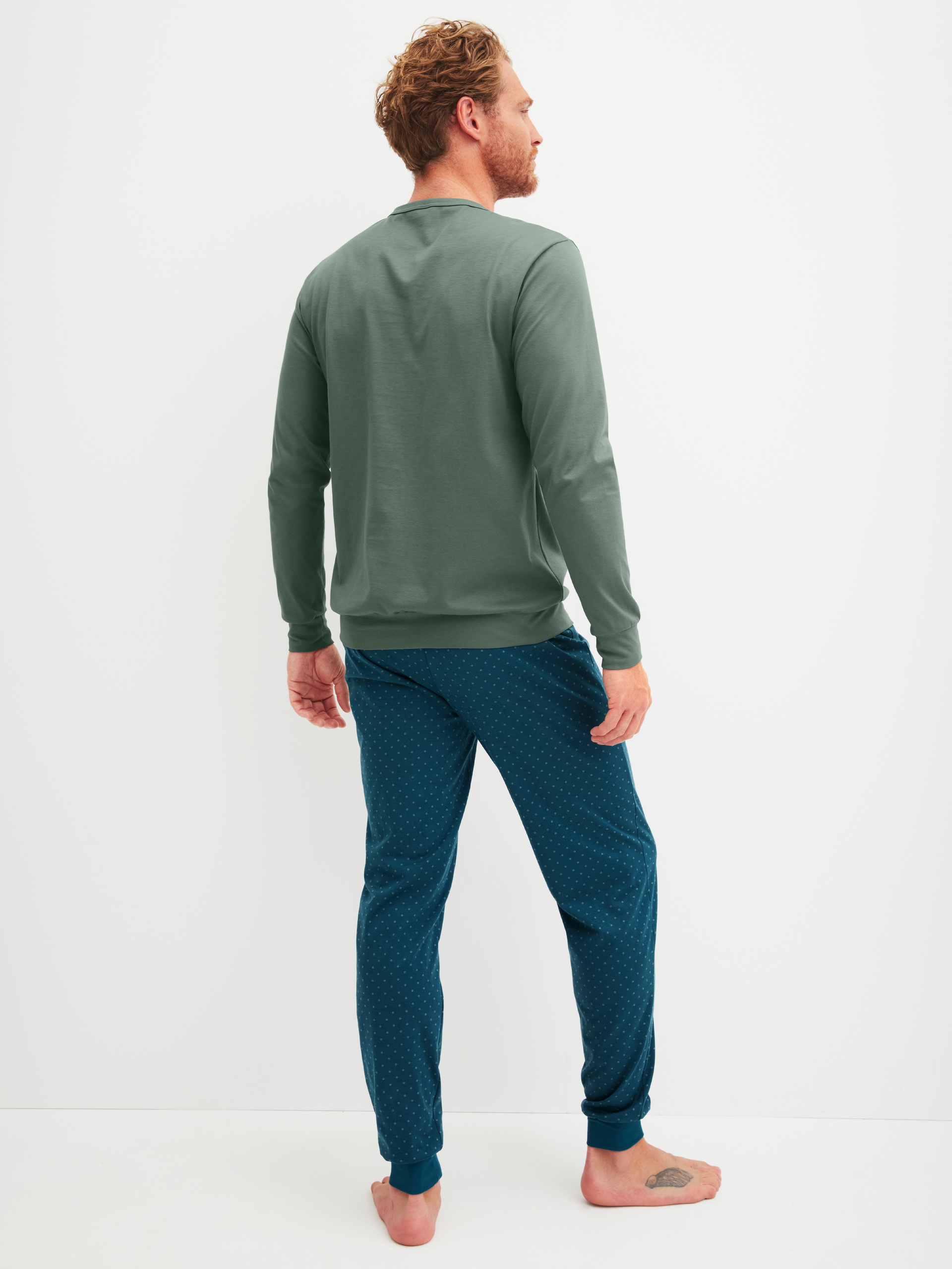 Herren-Model trägt Bündchen-Pyjama aus 100% Baumwolle in Grün, Gemustert aus Serie Relax Imprint 1 von CALIDA, Rückansicht