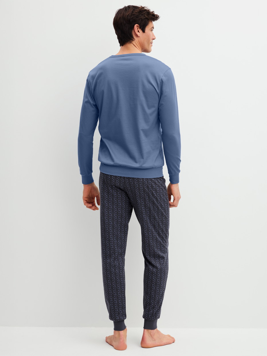 Herren-Model trägt Bündchen-Pyjama aus 100% Baumwolle in Blau, Gemustert aus Serie Relax Imprint 1 von CALIDA, Rückansicht