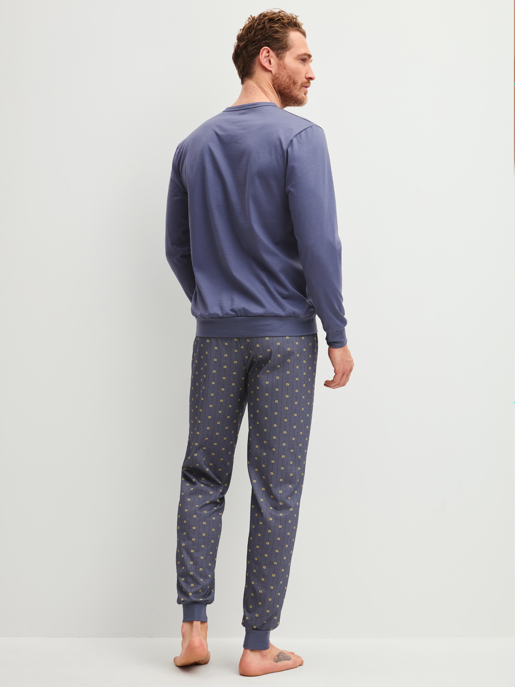 Herren-Model trägt Bündchen-Pyjama aus 100% Baumwolle in Grau, Gemustert aus Serie EDITION 85 von CALIDA, Rückansicht
